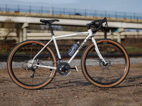 Surly Midnight Special bike side view near railroad tracks, hiway overpass in background